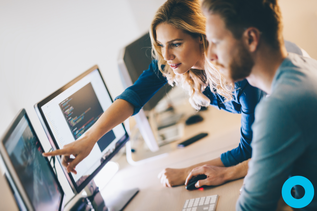 Office manager for a dental office showing software to a colleague